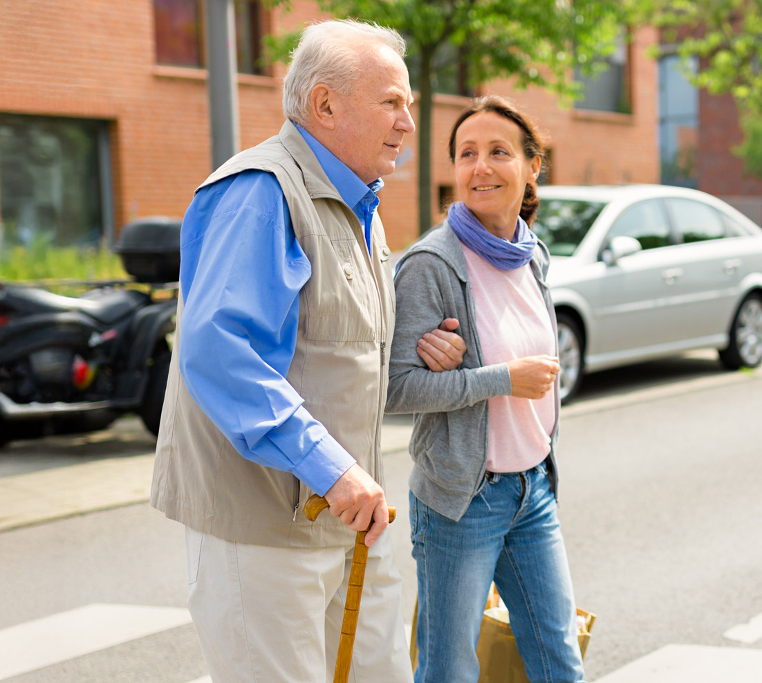 teilhabe_inklusion Eine Assistentin stützt einen älteren Mann